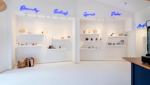 Bright, minimalist store interior with shelves displaying various products, labeled "Beauty," "Relief," "Great," and "Pale."