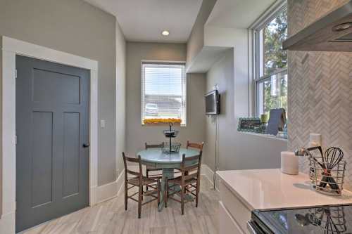 Cozy kitchen nook with a round table, chairs, and a window, featuring light-colored walls and modern decor.
