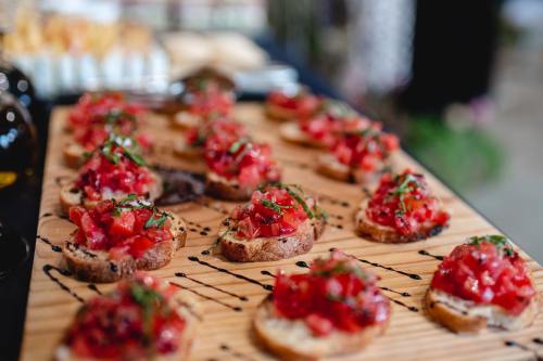 A wooden platter of bruschetta topped with diced tomatoes and fresh herbs, drizzled with balsamic glaze.