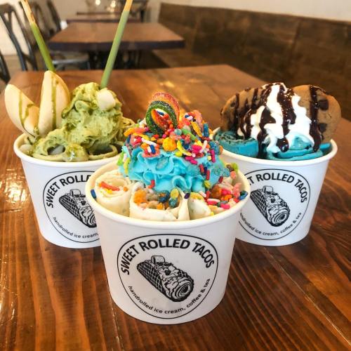 Three colorful ice cream cups with unique toppings: green tea, blue raspberry, and a cookie dough flavor, all in branded cups.