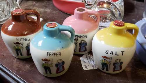 Four small ceramic jars labeled "Nutmeg," "Pepper," "Cinnamon," and "Salt," each with a colorful design.