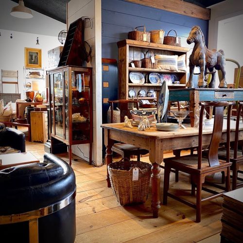 A cozy interior filled with vintage furniture, decorative items, and wooden accents, creating a warm, inviting atmosphere.