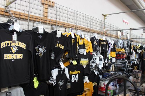 A display of Pittsburgh sports merchandise, featuring jerseys and apparel for the Penguins and Steelers.