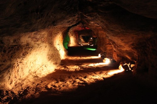 A dimly lit cave interior with winding paths and illuminated rock formations.