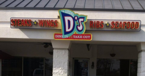 Sign for D's restaurant featuring steaks, wings, ribs, and seafood, with options for dine-in or takeout.