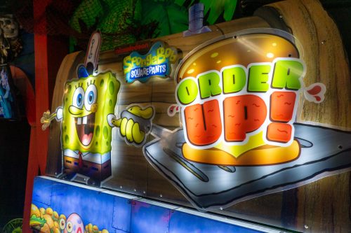 Colorful sign featuring SpongeBob SquarePants with the text "ORDER UP!" in a playful, cartoonish style.