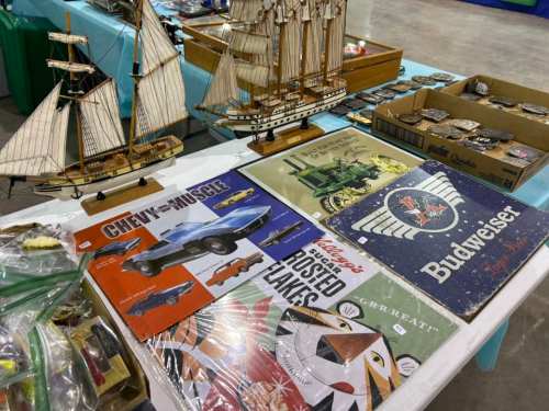 A display of vintage items including model ships, posters, and various collectibles on a table.