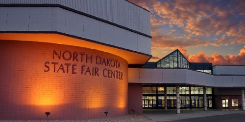 Exterior of the North Dakota State Fair Center at sunset, featuring modern architecture and vibrant sky colors.
