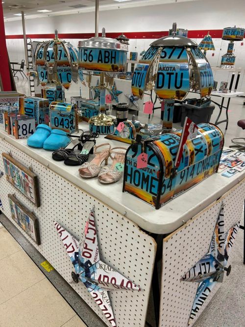 A display of decorative items made from vintage license plates, including a mailbox and various accessories.