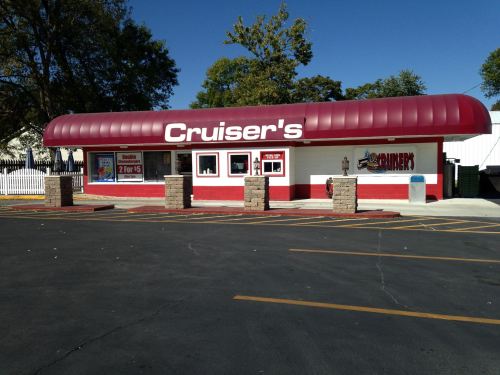 A red and white building with a curved roof, labeled "Cruiser's," featuring large windows and a parking lot.