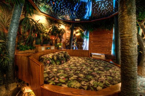 A cozy round bed surrounded by tropical plants and a starry ceiling, creating a serene, nature-inspired atmosphere.