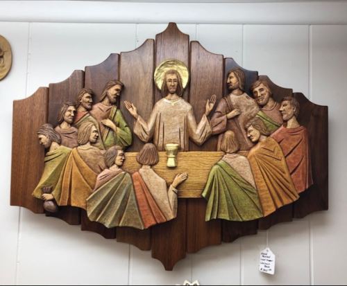 Wooden relief depicting Jesus and twelve apostles at the Last Supper, with vibrant colors and intricate details.