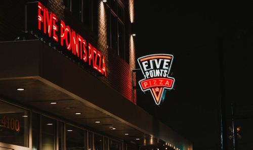 Neon sign for Five Points Pizza illuminated at night, showcasing the restaurant's name and logo.