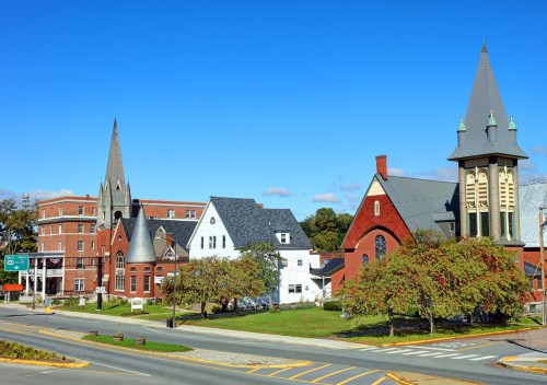 A scenic view of a small town featuring historic buildings, churches, and a clear blue sky.