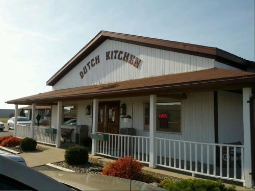 A white building with a brown roof and sign reading "Dutch Kitchen," featuring an open sign in the window.