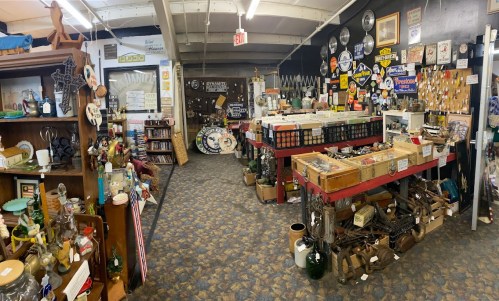 A vintage shop interior filled with various antiques, collectibles, and signs, showcasing a nostalgic atmosphere.