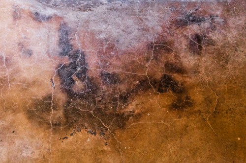 Textured surface with a mix of earthy tones, featuring cracks and subtle variations in color.