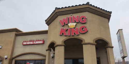 Exterior of a restaurant named "Wing King," featuring a large sign and a decorative architectural style.