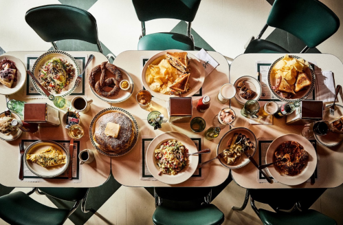 Aerial view of a table set with various colorful dishes, drinks, and snacks, showcasing a vibrant meal spread.