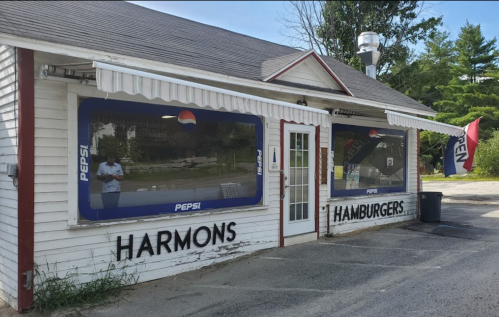 A small white building with "Harmons Hamburgers" signage and Pepsi advertisements on the windows.
