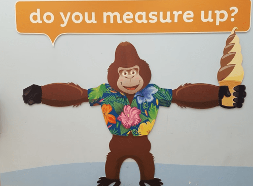 A cartoon gorilla in a floral shirt holds an ice cream cone, with the text "do you measure up?" above it.