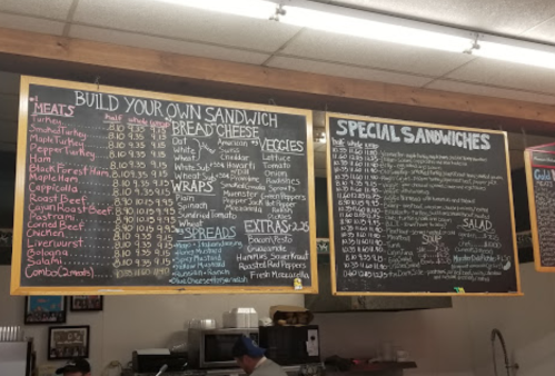 Menu board displaying options for building sandwiches, including meats, breads, cheeses, veggies, and special sandwiches.