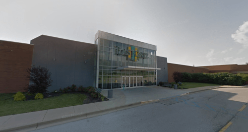 Exterior view of East Gate shopping center, featuring a modern glass entrance and landscaped surroundings.