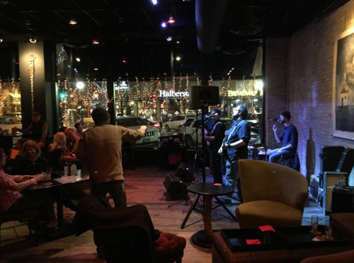 A lively music performance in a cozy venue, with a band playing and an audience enjoying the atmosphere.