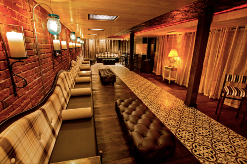 Cozy lounge with plush seating, patterned flooring, and warm lighting, creating an inviting atmosphere.