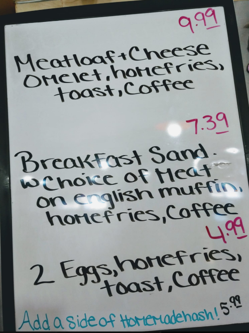 Menu board featuring breakfast items with prices: Meatloaf & Cheese Omelet, Breakfast Sandwich, and 2 Eggs with toast.