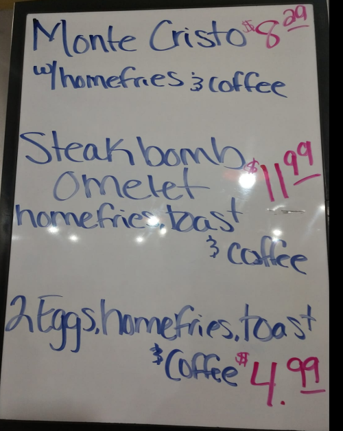 Menu board featuring breakfast items: Monte Cristo, Steak Bomb Omelet, and 2 Eggs with homefries and coffee, with prices listed.