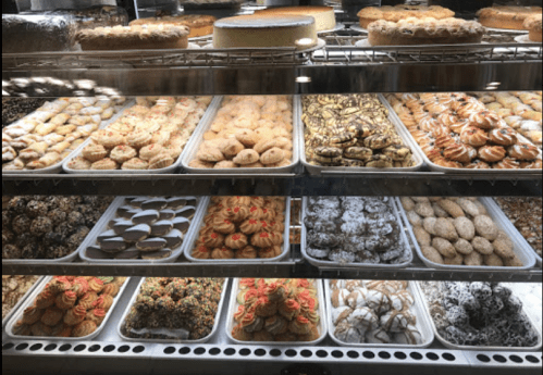 A display case filled with a variety of colorful pastries and desserts, including cookies and cakes.