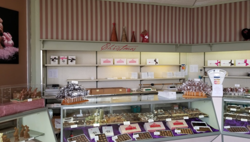A festive candy shop display with various chocolates and treats, decorated for Christmas.