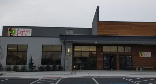 Exterior of a modern building with a sign reading "Patty's," featuring large windows and a mix of materials.