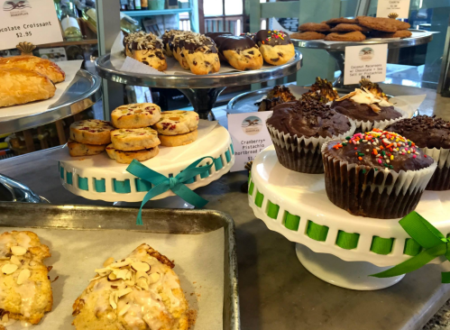 A display of assorted baked goods, including croissants, cookies, and cupcakes, beautifully arranged on tiered stands.