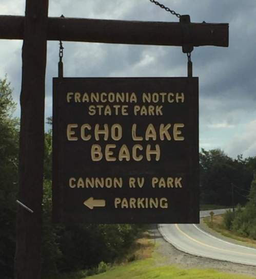 Sign for Echo Lake Beach at Franconia Notch State Park, with directions to Cannon RV Park and parking.