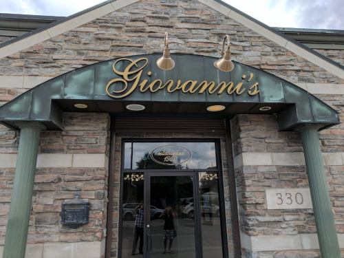 Exterior of Giovanni's restaurant, featuring a stone facade and a decorative sign above the entrance.