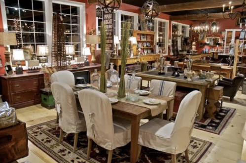 A cozy interior showcasing a variety of rustic furniture, including tables, chairs, and decorative items.