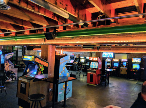A retro arcade with various classic game machines and a cozy, dimly lit atmosphere.