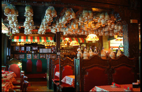 Cozy restaurant interior with wooden decor, red seating, and unique hanging light fixtures.