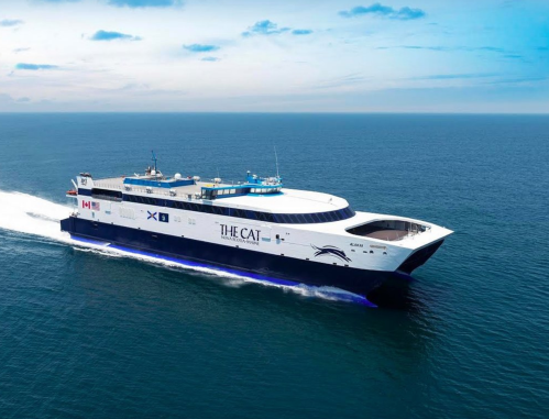 A large ferry named "The Cat" sailing on calm blue waters under a clear sky.