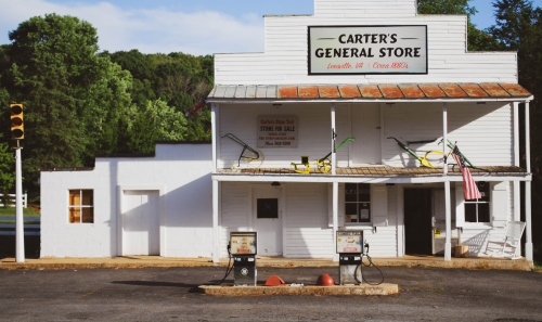 Historic Carter's General Store with vintage gas pumps, located in Louisa, VA, surrounded by greenery.