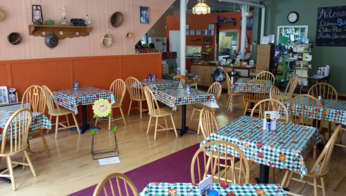 Cozy café interior with checkered tablecloths, wooden chairs, and a welcoming atmosphere.