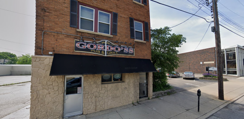 Exterior view of Gordo's Pub & Grill, featuring a brick building with a sign and an awning, on a sunny day.