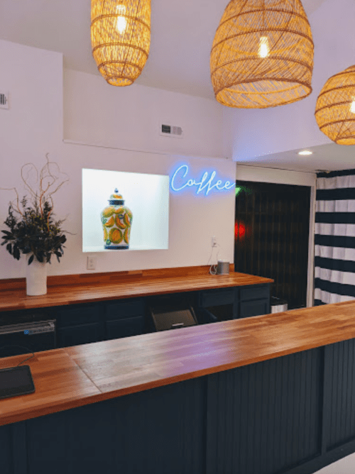 A cozy coffee shop interior featuring a wooden counter, decorative lighting, and a vibrant coffee-themed display.