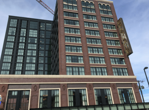 A tall, modern building with a brick facade and large windows, featuring a sign that reads "Graduate."