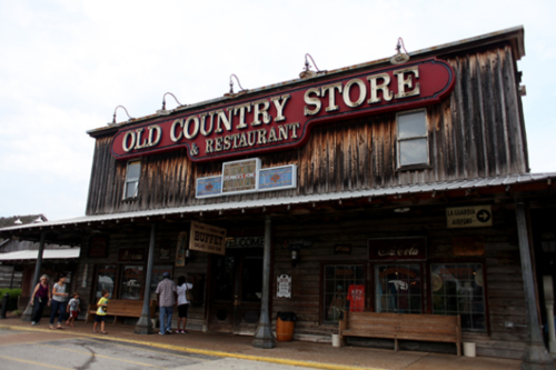 Exterior of the Old Country Store & Restaurant, featuring rustic wooden architecture and a welcoming sign.