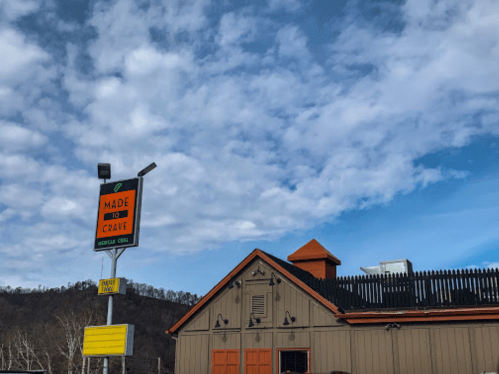 A restaurant building with a sign reading "Made to Crave" under a partly cloudy sky.