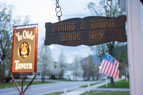Sign for Ye Olde Tavern, featuring "Wining & Dining Since 1790," with an American flag in the background.