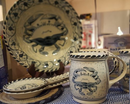 A collection of blue and white ceramic dishes featuring crab designs, including a pitcher and plates.